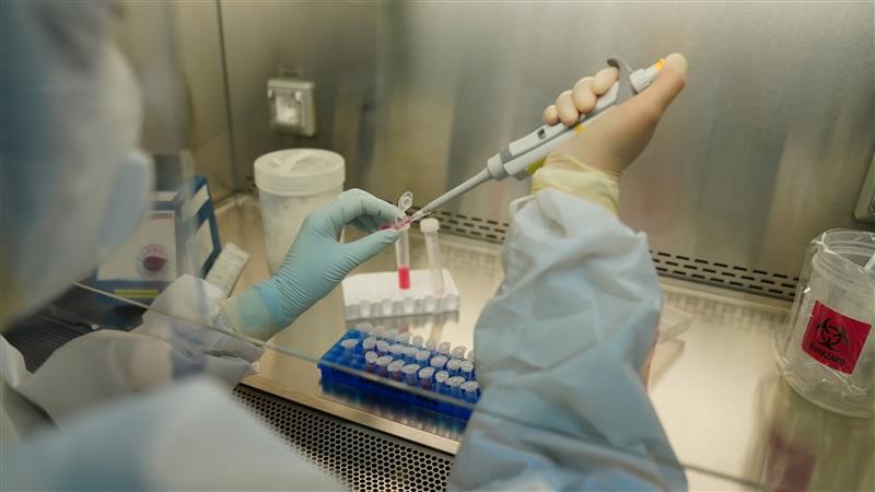 midsection scientist pipetting liquid bottles